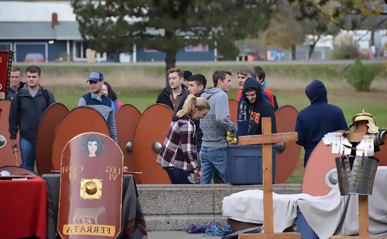 Students prepare for reenactment amongst Medieval shields